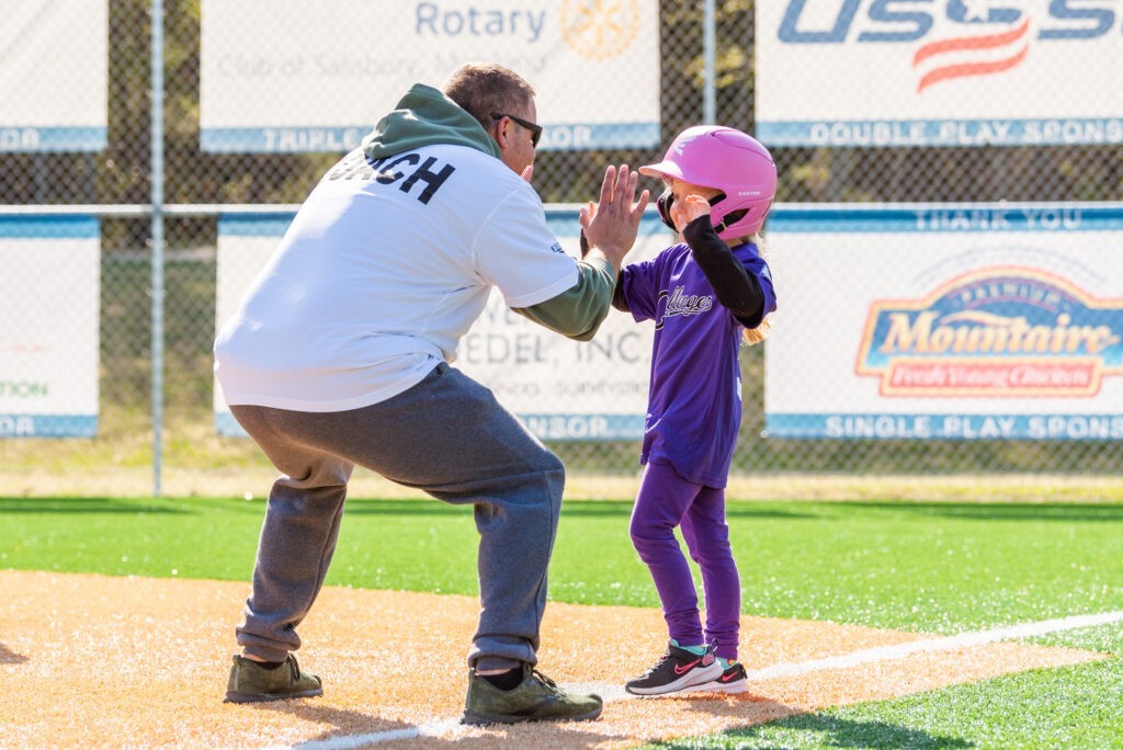 a man and a little girl on a baseball field