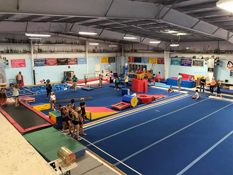 an indoor gym filled with children and adults