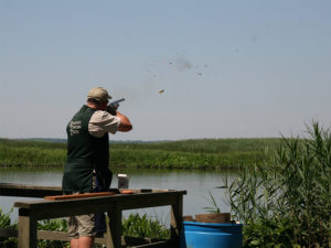 a man is shooting a bird with a gun