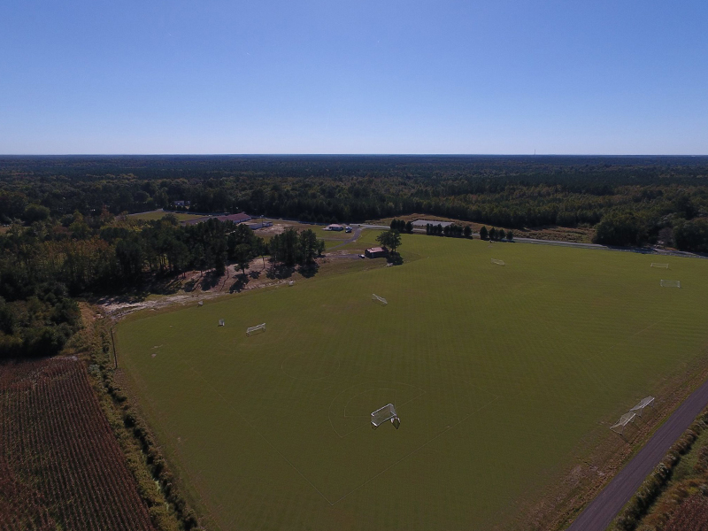 an aerial view of a soccer field surrounded by trees