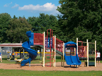 children playing in a park with a blue and yellow slide