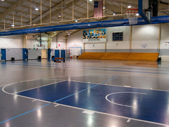 an indoor basketball court with blue and white lines