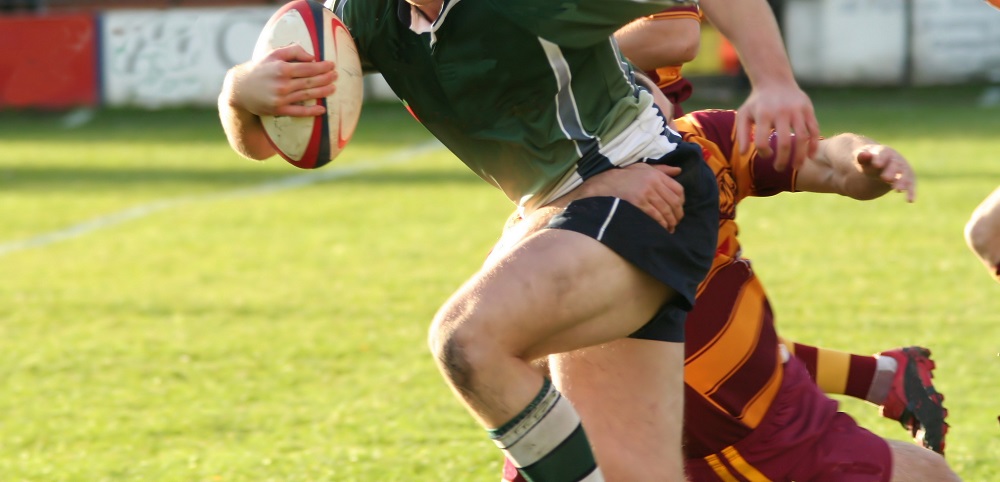 a man holding onto another man while playing rugby